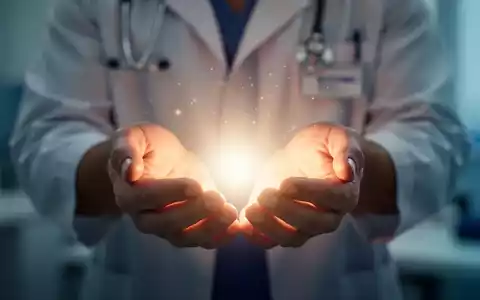 Hände halten sanft ein leuchtendes, ätherisches Licht, das ganzheitliche Heilung und Wohlbefinden symbolisiert. - Foto: über boerse-global.de