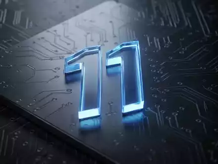 A glowing blue Windows 11 logo on a dark, metallic surface with subtle circuit board patterns, symbolizing a technology update. - Foto: über boerse-global.de