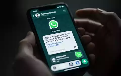 Nahaufnahme eines Smartphones mit einer betrügerischen WhatsApp-Nachricht, die auf Finanzbetrug hinweist. - Foto: über boerse-global.de