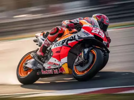 Ein MotoGP-Motorrad in voller Fahrt auf einer Rennstrecke, der Fahrer lehnt sich in einer Kurve, unscharfer Hintergrund vermittelt Geschwindigkeit. - Foto: über boerse-global.de