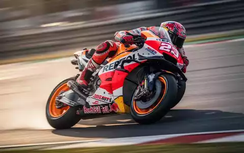 Ein MotoGP-Motorrad in voller Fahrt auf einer Rennstrecke, der Fahrer lehnt sich in einer Kurve, unscharfer Hintergrund vermittelt Geschwindigkeit. - Foto: über boerse-global.de