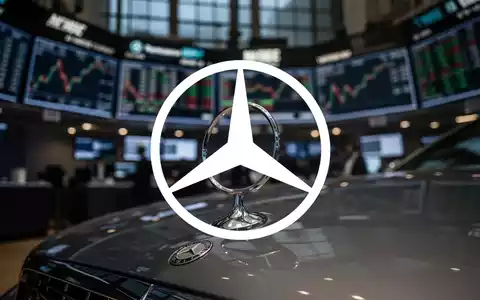 Mercedes-Benz Stern auf Motorhaube, unscharfer Hintergrund mit Börsenparkett bei Dämmerung, der einen Marktabschwung andeutet. - Foto: über boerse-global.de