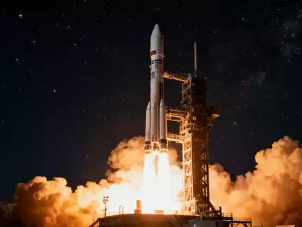 Eine Rakete startet nachts, mit leuchtendem Abgasstrahl und Rauch auf dem Startplatz. - Foto: über boerse-global.de