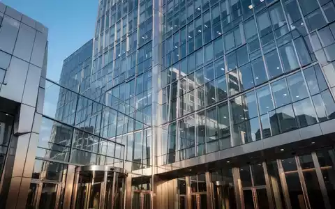 Moderne Glas- und Stahlfassade eines Bankgebäudes, das einen klaren blauen Himmel widerspiegelt. - Foto: über boerse-global.de