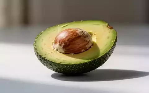 Eine perfekt halbierte Avocado mit sichtbarem Kern und leuchtend grünem Fruchtfleisch auf einer minimalistischen Oberfläche. - Foto: über boerse-global.de