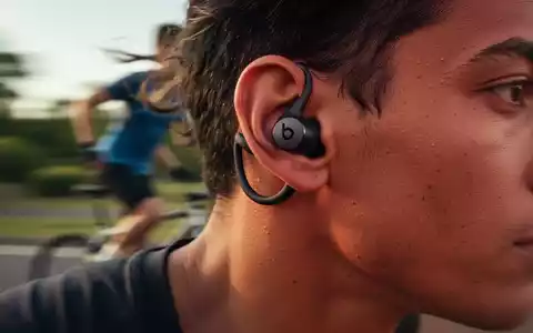 Close-up of a dark Beats Fit Pro earbud in a person's ear during exercise, highlighting its secure wingtip design. - Foto: über boerse-global.de