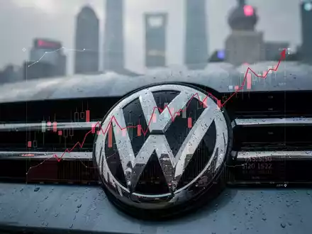 Ein detailliertes Volkswagen-Emblem, teilweise verdeckt von einem fallenden Finanzgrafik, mit einer unscharfen Shanghai-Skyline im Hintergrund. - Foto: über boerse-global.de