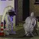 Beamte der Spurensicherung in Spurensicherungsanzügen begutachten den Tatort. - Bild: Christoph Reichwein/dpa