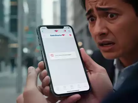 Ein Smartphone zeigt eine Fehlermeldung auf der Bank of America App, gehalten von einer Person mit besorgtem Gesichtsausdruck. - Foto: über boerse-global.de