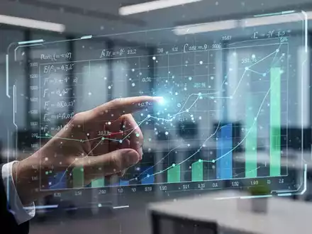 A hand interacts with a futuristic, glowing spreadsheet interface on a transparent screen, showing data and formulas. - Foto: über boerse-global.de