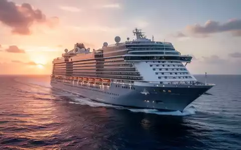 Ein großes Kreuzfahrtschiff auf offener See bei Sonnenaufgang, mit dem Bug zum Betrachter gerichtet. - Foto: über boerse-global.de