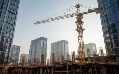 Eine Baustelle mit einem einzelnen Kran vor einer Skyline moderner Gebäude, symbolisiert Wachstum und Entwicklung. - Foto: über boerse-global.de