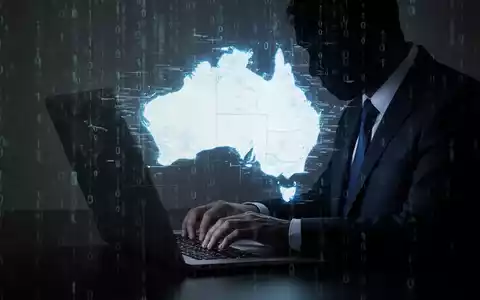 A shadowy figure typing on a laptop with a distorted map of Australia and binary code, representing a cyberattack. - Foto: über boerse-global.de