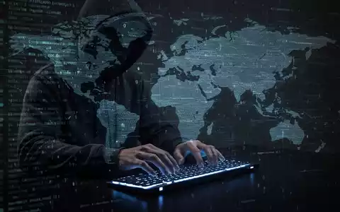 A shadowy figure in a hoodie typing on a keyboard, with digital code and a world map overlay, symbolizing cybercrime. - Foto: über boerse-global.de