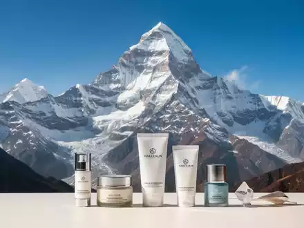 Ein majestätischer, schneebedeckter Himalaja-Gipfel mit klarem blauem Himmel. Im Vordergrund, dezent arrangierte Premium-Konsumgüter. - Foto: über boerse-global.de