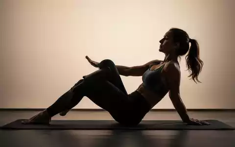 Eine Frau in Sportkleidung führt eine Pilates-Übung auf einer Matte aus, die die Rumpfmuskulatur stärkt. - Foto: über boerse-global.de