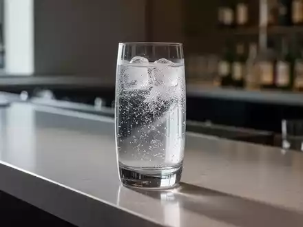 Ein elegantes Glas mit einem klaren, kalorienarmen Getränk auf einem modernen Bartresen, symbolisiert gesunden Alkoholkonsum. - Foto: über boerse-global.de
