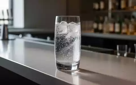 Ein elegantes Glas mit einem klaren, kalorienarmen Getränk auf einem modernen Bartresen, symbolisiert gesunden Alkoholkonsum. - Foto: über boerse-global.de