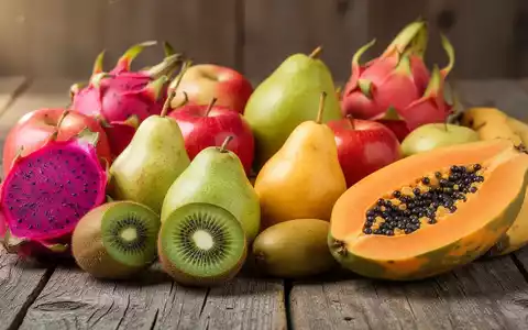 Eine Stillleben-Anordnung von frischen Kiwis, Birnen, Äpfeln, Papayas und Drachenfrüchten auf einer Holzoberfläche. - Foto: über boerse-global.de