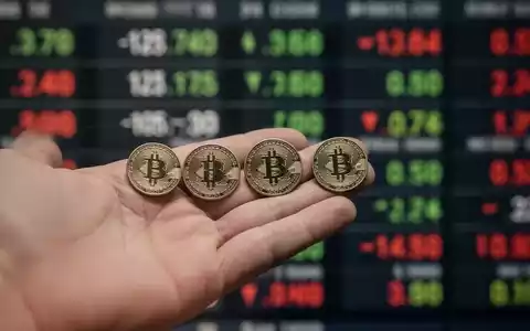 Eine Hand hält fünf identische Finanzmarken, wobei eine leicht getrennt ist, vor einem verschwommenen Börsenticker. Das Bild symbolisiert einen Aktiensplit. - Foto: über boerse-global.de