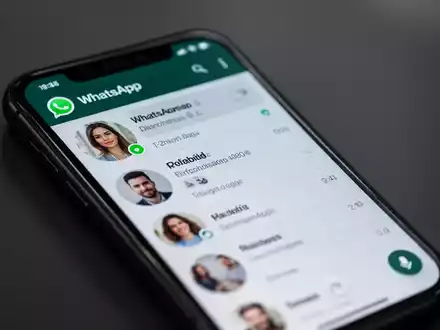 Ein Smartphone-Bildschirm zeigt die WhatsApp-Benutzeroberfläche mit einer Kontaktliste, auf der ein grüner Punkt den Online-Status anzeigt. - Foto: über boerse-global.de