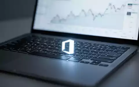 Close-up of a laptop keyboard with a subtle Microsoft Office logo on a key, screen blurred with a financial chart. - Foto: über boerse-global.de