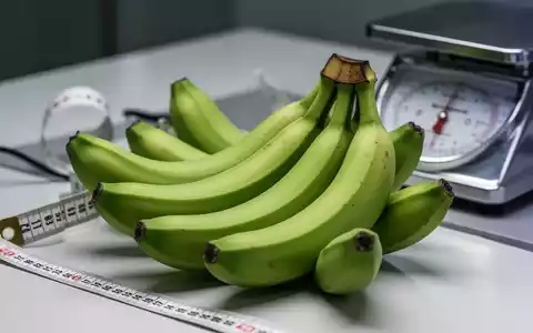 Nahaufnahme von mehreren grünen Bananen auf einer hellen Oberfläche, die ihre unreife Textur und Farbe hervorhebt. - Foto: über boerse-global.de