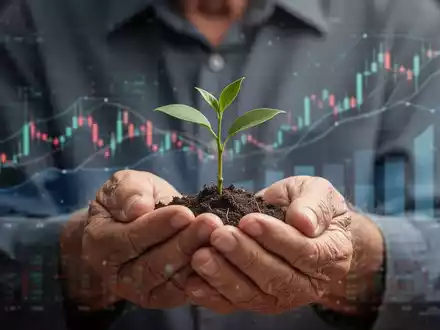 Ältere Hände halten eine kleine Pflanze, mit verschwommenen Finanzdiagrammen im Hintergrund, symbolisiert Vorsorge für langes Leben. - Foto: über boerse-global.de