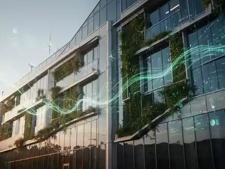 Eine moderne, energieeffiziente Gebäudefassade mit grünen Technologien, die einen klaren Himmel widerspiegelt und digitale Datenströme andeutet. - Foto: über boerse-global.de
