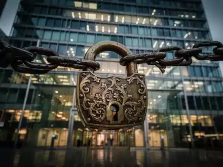 Ein großes, verziertes, antikes Schloss und eine Kette blockieren den Eingang zu einem Commerzbank-Gebäude. - Foto: über boerse-global.de