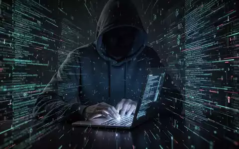 A person in a hoodie typing on a laptop, surrounded by digital code, symbolizing a cyberattack and data breach. - Foto: über boerse-global.de