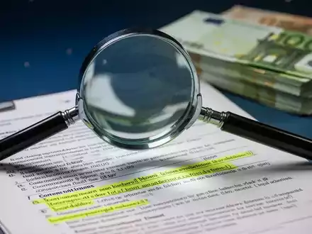 Eine Lupe über einem juristischen Dokument, das Schlupflöcher und eine große Summe Euro-Banknoten symbolisiert. - Foto: über boerse-global.de
