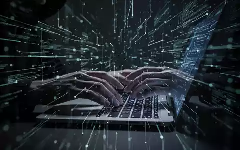 Hände tippen auf einer beleuchteten Laptop-Tastatur, umgeben von digitalen Linien, die Cyberkriminalität und Datenklau darstellen. - Foto: über boerse-global.de