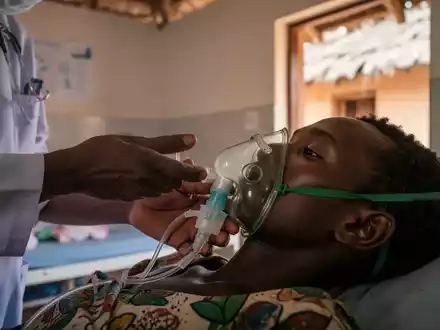 Gesundheitsarbeiter justiert Sauerstoffmaske eines Patienten in einer medizinischen Einrichtung in Madagaskar. - Foto: über boerse-global.de