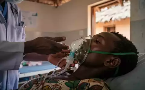 Gesundheitsarbeiter justiert Sauerstoffmaske eines Patienten in einer medizinischen Einrichtung in Madagaskar. - Foto: über boerse-global.de
