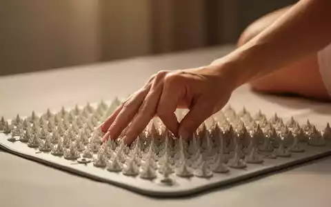 Eine Hand drückt sanft auf eine Akupressurmatte mit vielen kleinen Spikes in einer ruhigen, entspannenden Umgebung. - Foto: über boerse-global.de