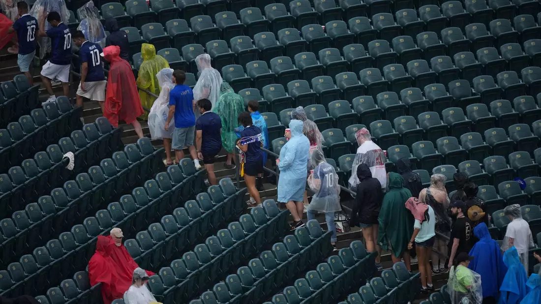 Unwetterwarnung: Fans verlassen die Ränge.  - Bild: Matt Rourke/AP/dpa