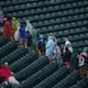 Unwetterwarnung: Fans verlassen die Ränge.  - Bild: Matt Rourke/AP/dpa