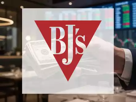 Eine Hand hält einen Stapel Geldscheine, im Hintergrund verschwommen ein Restaurant oder Finanzdaten. - Foto: über boerse-global.de