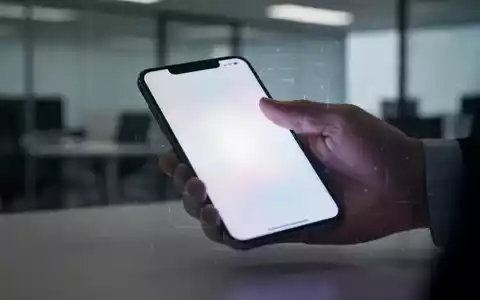 Eine Hand legt ein leuchtendes Smartphone weg, unscharfer Hintergrund eines Büros. Symbolisiert das Recht auf Nichterreichbarkeit. - Foto: über boerse-global.de