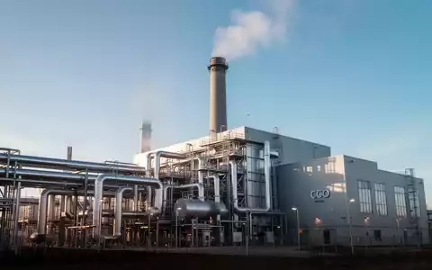 Eine moderne CO2-Abscheidungsanlage in Schweden mit Industrierohren und einem Schornstein unter blauem Himmel. - Foto: über boerse-global.de