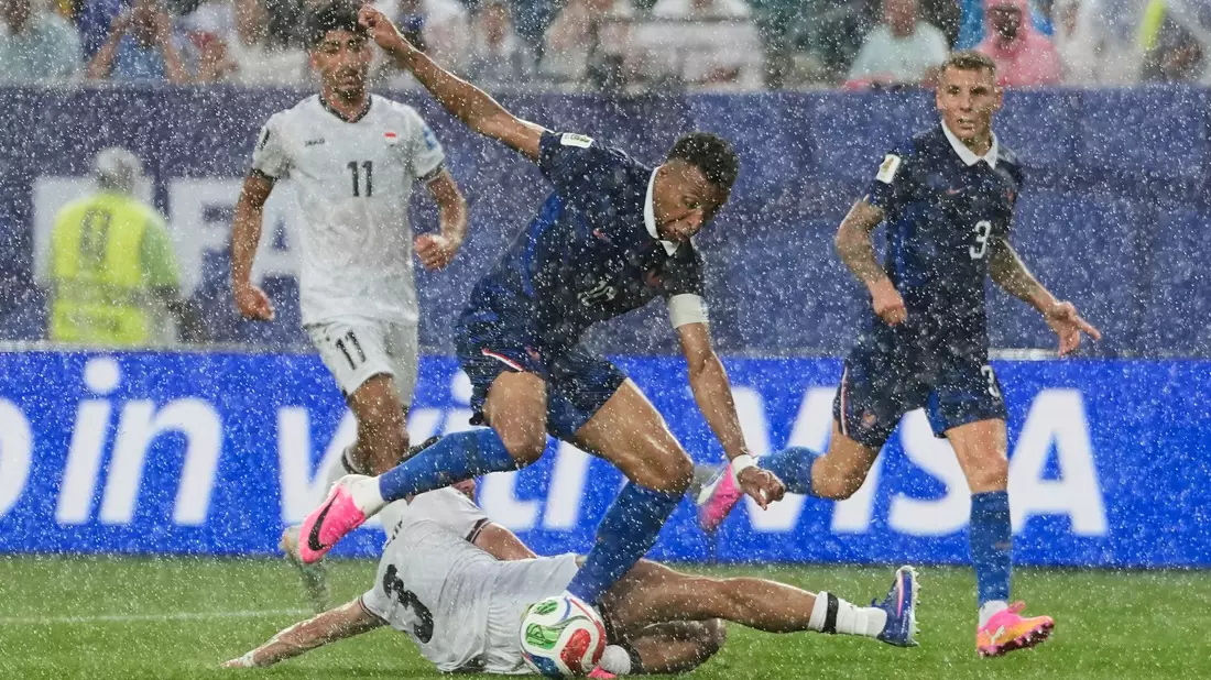 Stürmerstar im Regen: Frankreichs Kylian Mbappé im Zweikampf mit dem Iraker Hussein Ali. - Bild: Matt Slocum/AP/dpa