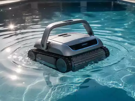 Ein moderner Poolroboter reinigt einen Swimmingpool unter Wasser. Das Wasser ist klar und blau, Sonnenlicht reflektiert auf der Oberfläche. - Foto: über boerse-global.de