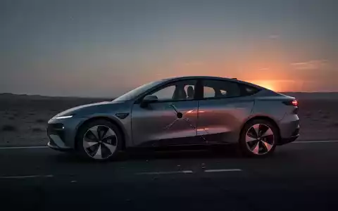 Ein modernes Elektroauto (XPeng-Stil) mit einem Riss in der Karosserie steht auf einer dunklen Straße bei Sonnenuntergang. - Foto: über boerse-global.de