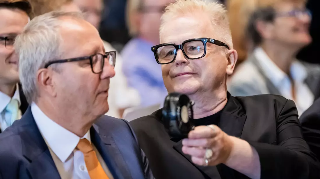 Es war warm bei der Verleihung: Herbert Grönemeyer hielt Andreas Voßkuhle, ehemaliger Präsident des Bundesverfassungsgerichts und Senatspräsident der Deutschen Nationalstiftung, daher einen Handventilator hin. - Bild: Christoph Soeder/dpa