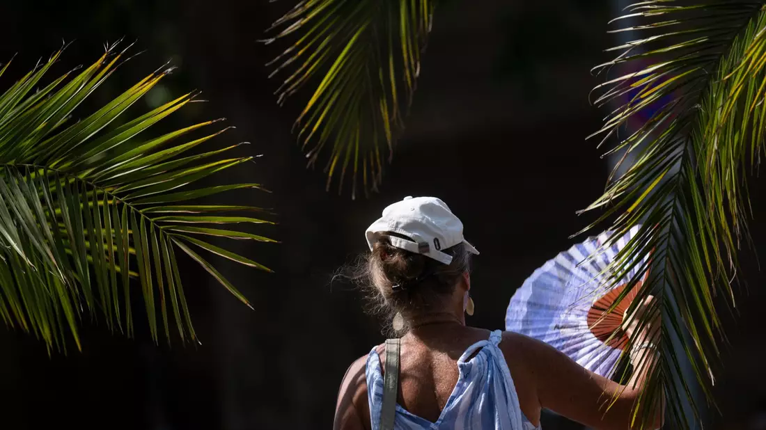 Ein Fächer, wie ihn hier eine Frau in Stuttgart bei sich trägt, ist derzeit ein gefragtes Sommer-Accessoire. - Bild: Marijan Murat/dpa