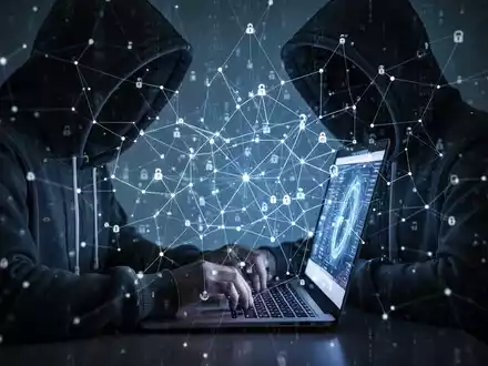 Eine Person mit Kapuze tippt auf einem Laptop, überlagert von einem abstrakten digitalen Netzwerk, das Datenspeicherung und Überwachung symbolisiert. - Foto: über boerse-global.de