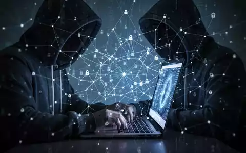 Eine Person mit Kapuze tippt auf einem Laptop, überlagert von einem abstrakten digitalen Netzwerk, das Datenspeicherung und Überwachung symbolisiert. - Foto: über boerse-global.de
