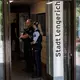 Einsatzkräfte stehen am Eingang des Rathauses. - Bild: David Ebener/dpa