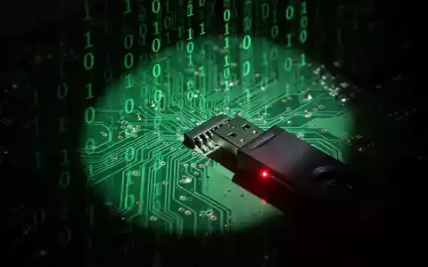 A glowing green circuit board with binary code, an ominous shadow, and a USB drive emitting a red light. - Foto: über boerse-global.de